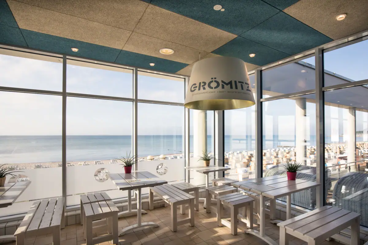 A room with tables, chairs and a large window.