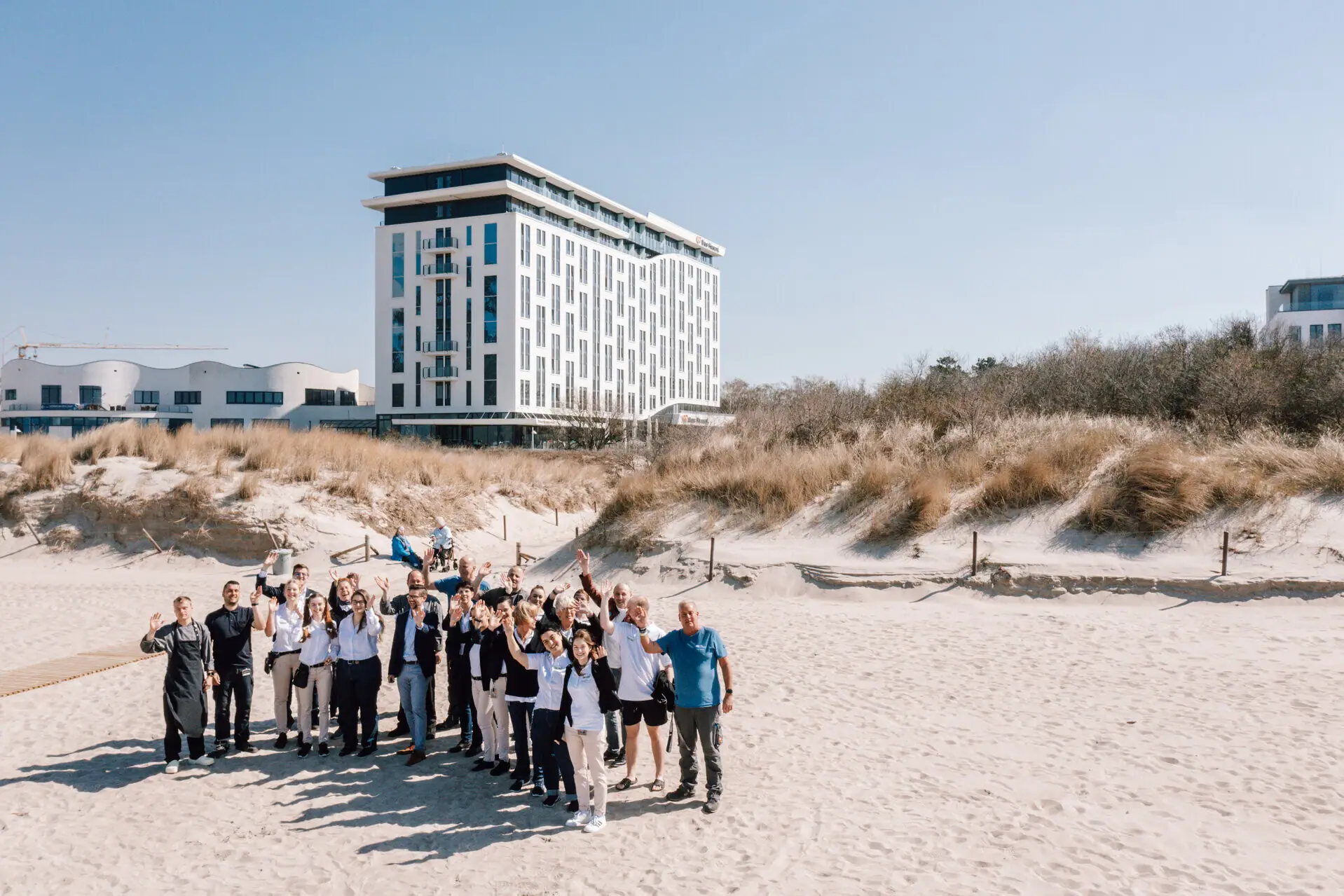 Team from the aja Warnemünde A group of people from the hotel team pose for a photo in front of the aja Warnemünde building.