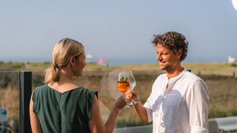 A man and woman holding wine glasses outdoors.