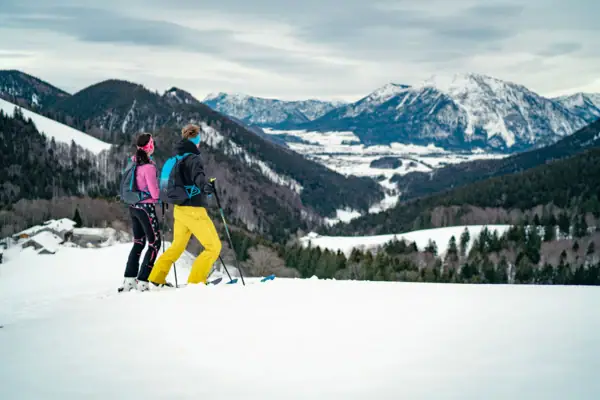 Winter in Ruhpolding A couple skiing on a snowy mountain.