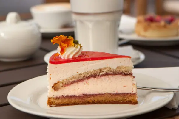 Cake A person pours a drink over a piece of cake.