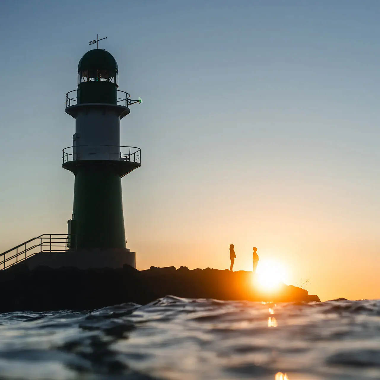 Offers at the aja Warnemünde Lighthouse in the water at sunset
