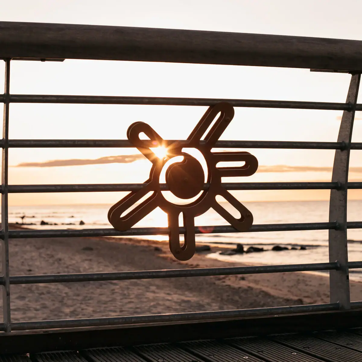 Sun on the pier Metal railing with sun symbol on it.