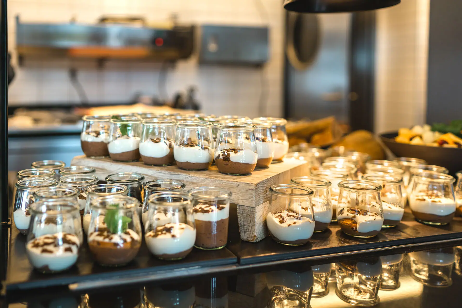 A group of small glasses filled with desserts.