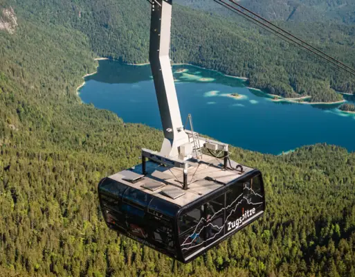 Cable car over a lake with mountains in the background