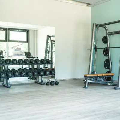 Strength range A gym with weights and a shelf full of equipment.