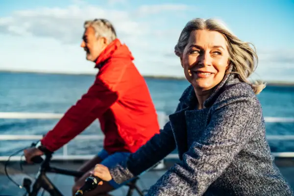 A man and a woman are cycling outdoors.