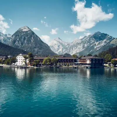 aja Fürstenhaus am Achensee Ein Gebäude neben einem Gewässer.