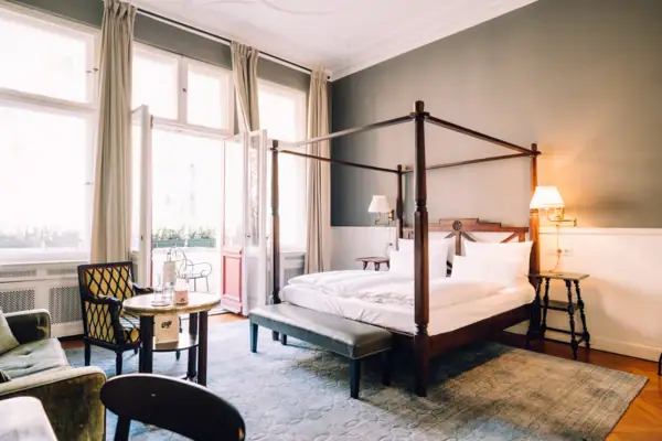 Room HENRI Berlin A room with a four-poster bed and a table.