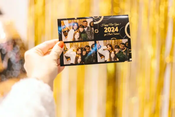 One hand holds a card with a group of people.