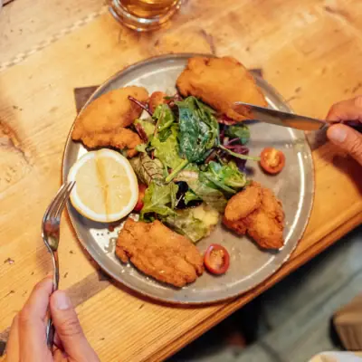 A person is eating a plate of fast food.