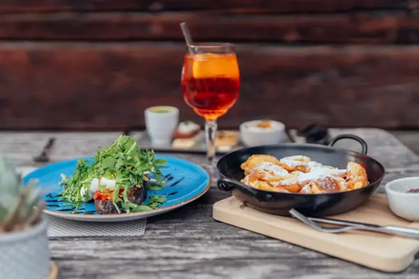 A plate of food and a drink on a table.