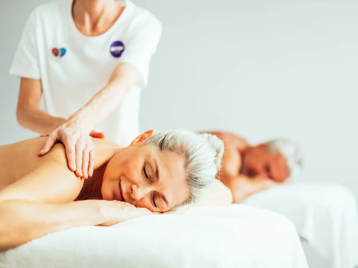 A woman lies on a bed with a man.