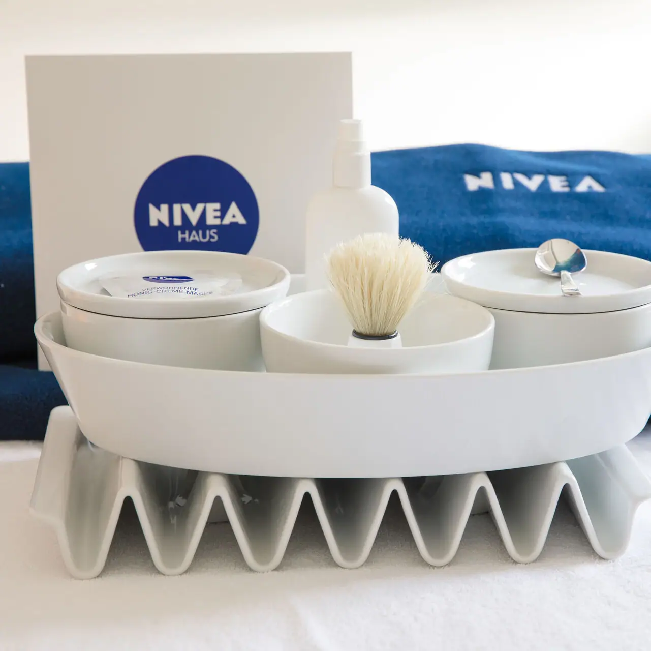 A white bowl with a brush and a bowl with a spoon on a white surface.