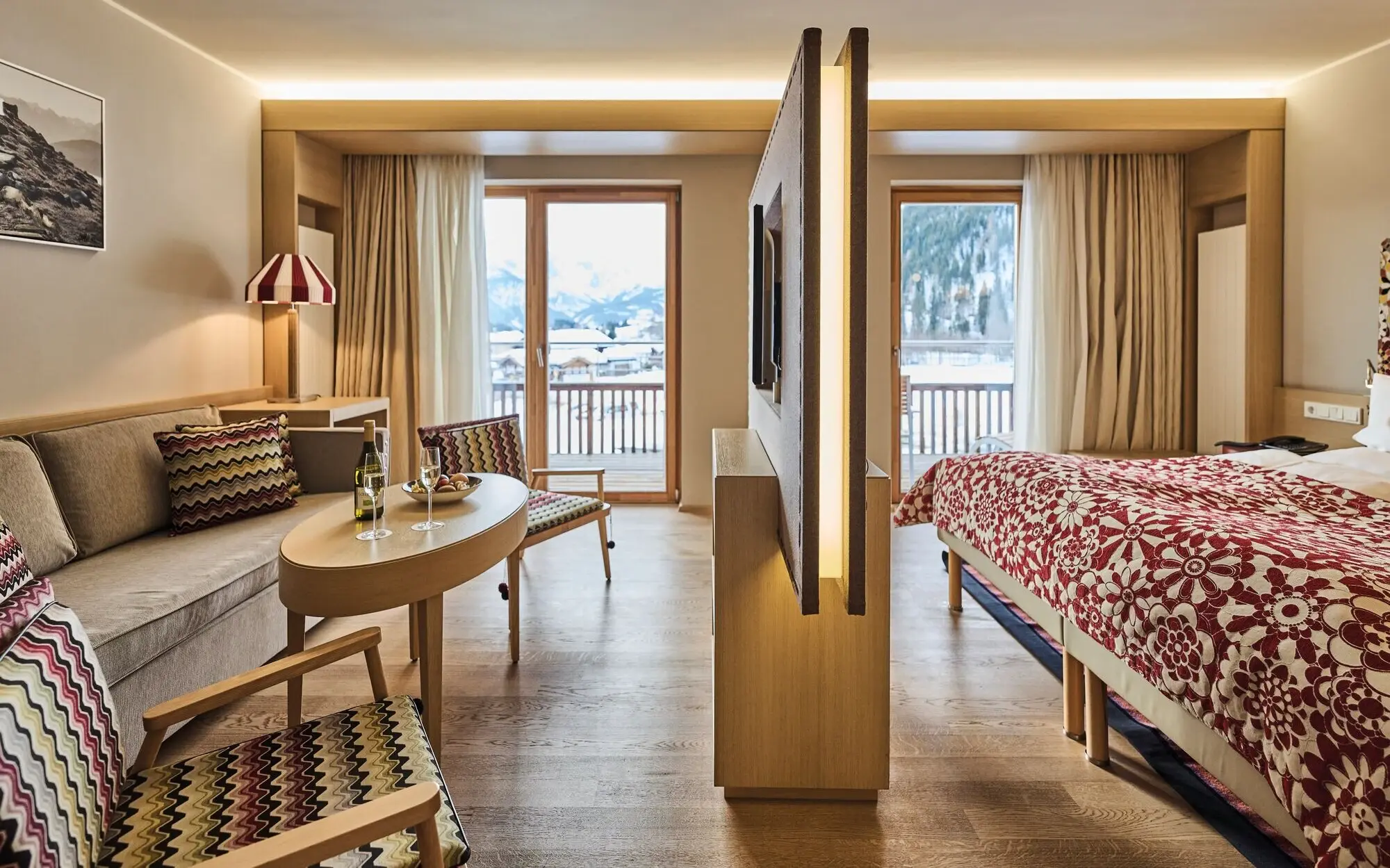 Interior of a bedroom with a bed and a table with chairs.