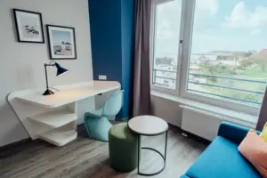 A room with a table, a chair and a window.