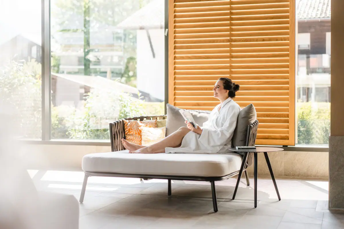 SPA lounger A woman in a white bathrobe sits on a sofa.