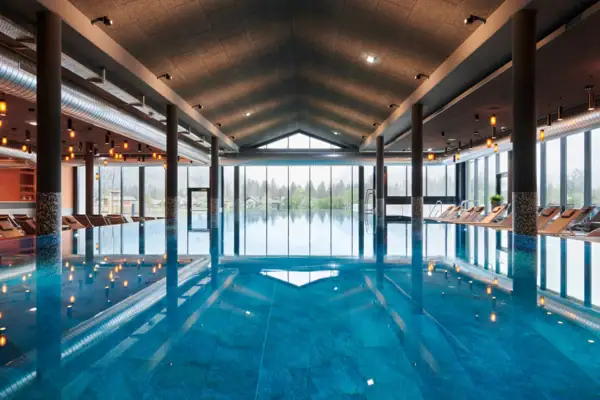Large indoor pool with high ceiling and large windows.