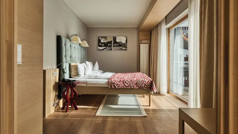 Hotel room Werfenweng Bedroom with bed and carpeted floor.