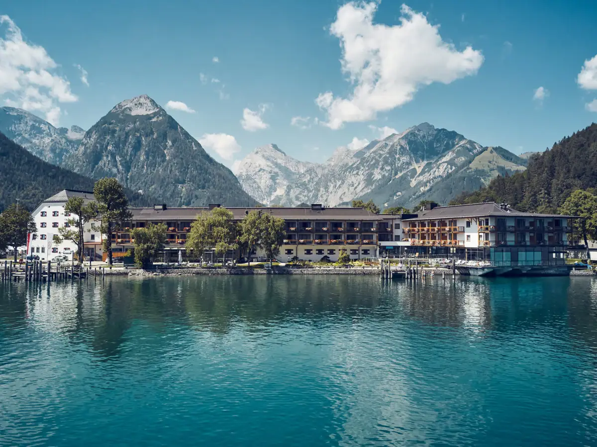 A building next to a body of water with mountains in the background.