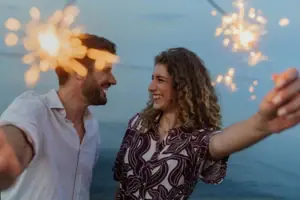 A man and a woman are celebrating New Year’s Eve in Bansin with sparklers.