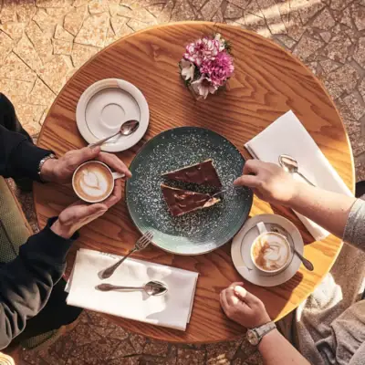 Café Nordstrand Two people sitting at a table with coffee and cake.
