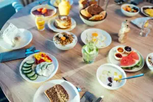 Ein Frühstückstisch mit Tellern voller Speisen und Getränken.