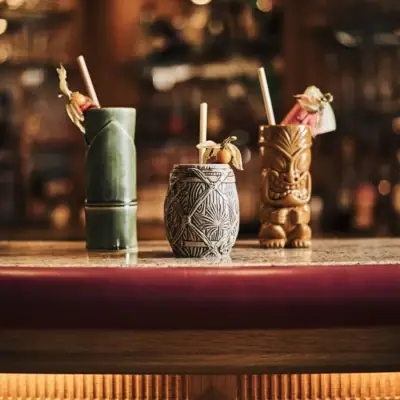 South Beach Bar A group of tiki mugs on a counter.