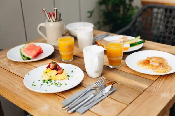 Ein Frühstückstisch mit Tellern voller Essen und Getränken.