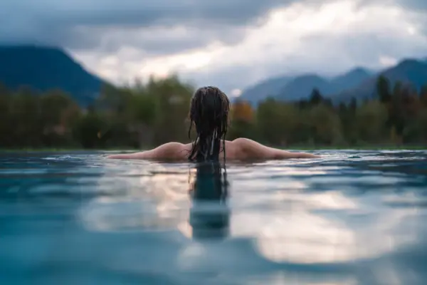 Wellness at Ruhpolding A woman is swimming in the pool at the aja Ruhpolding, with a view of the mountains.