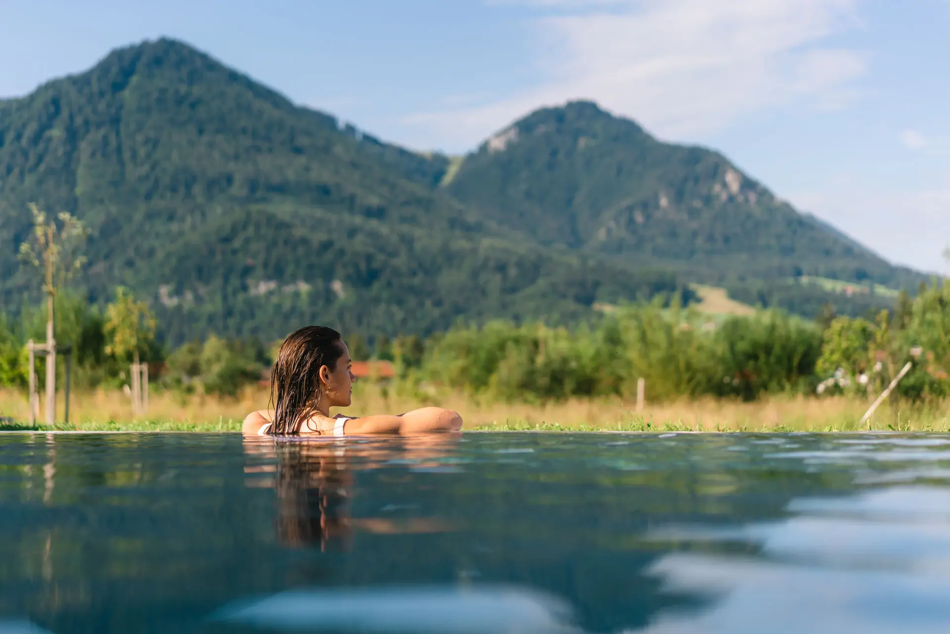 A woman in the pool with mountains in the background