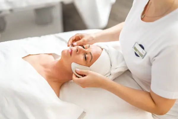 A woman receives a facial massage.
