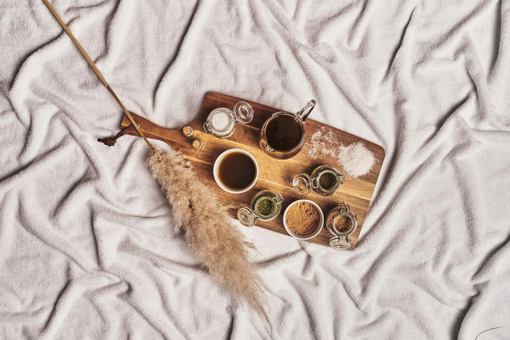 Tray with scrubs and spices on a white blanket