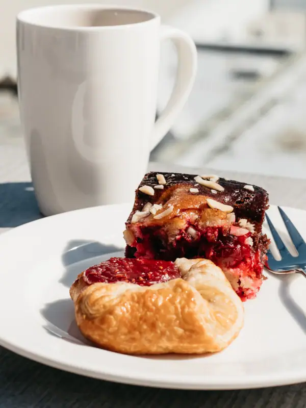 A plate of pastries and a cup of coffee on a table.