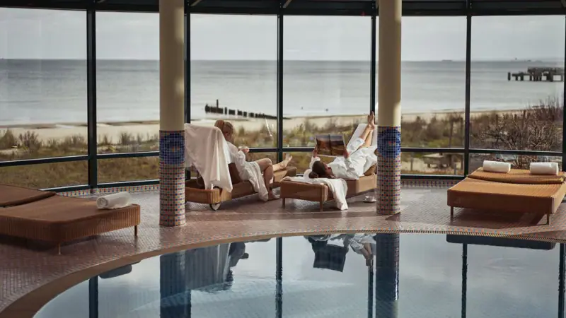 A couple in white bathrobes by the pool.