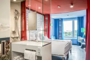 A room with a double bed and a washbasin.