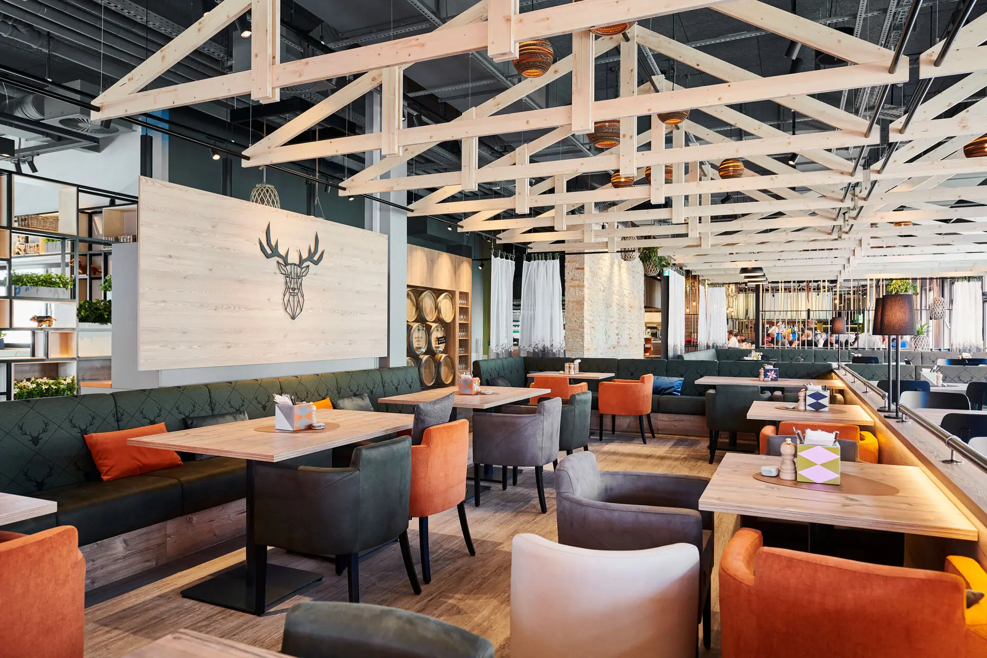 Restaurant interior with tables and orange and gray chairs and light wooden beams on the ceiling