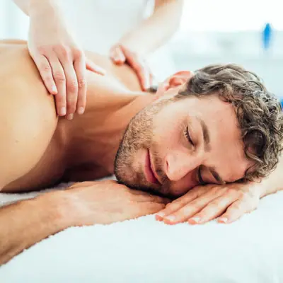 A man lies on a white surface.