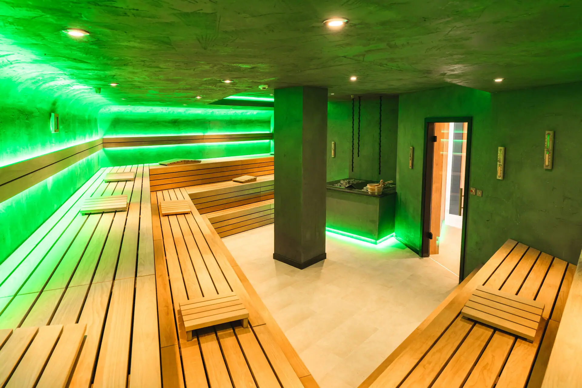 Sauna A room with green walls and wooden benches.