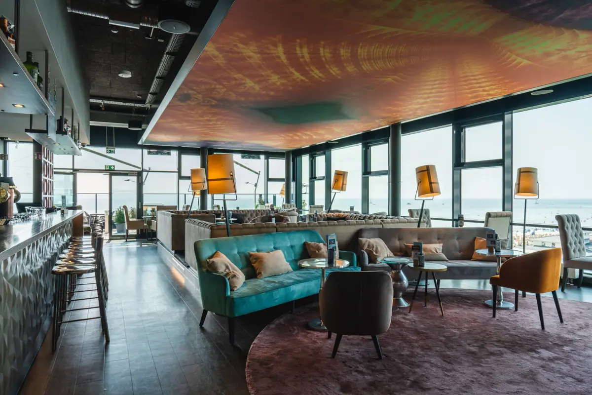 A room with a large window and a sofa.