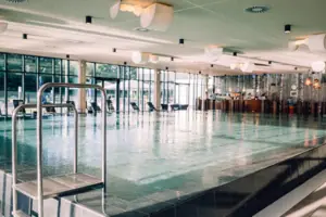A large indoor swimming pool with clear water and modern architecture.