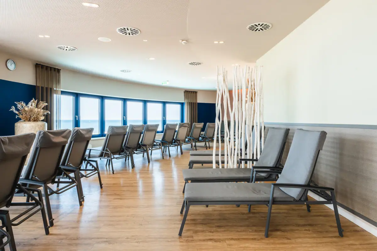 Relaxation area at the aja Warnemünde A room with loungers and windows.