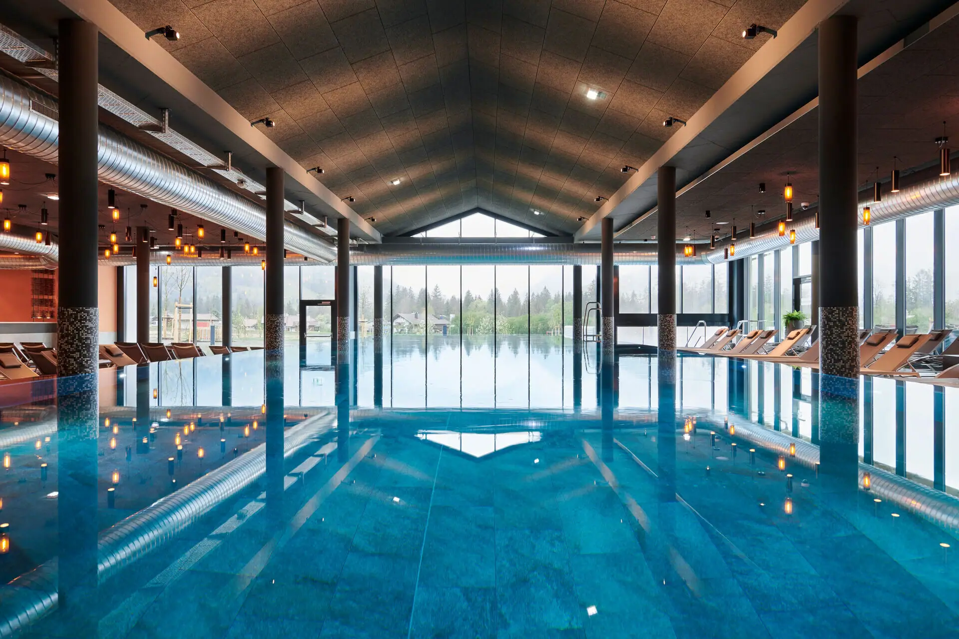 Indoor pool at aja Ruhpolding Large indoor pool with high ceiling and large windows.