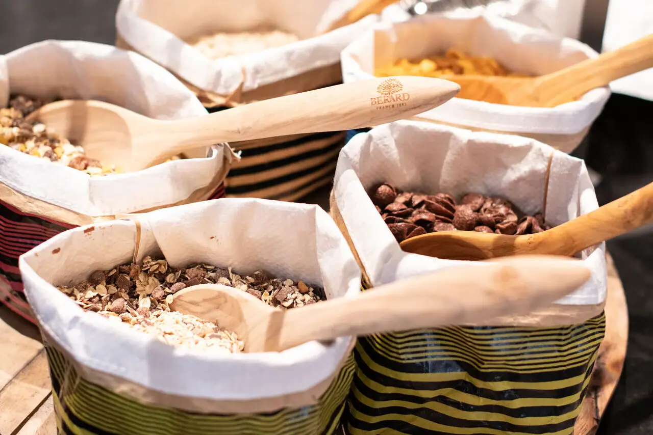 A group of bowls with wooden spoons.