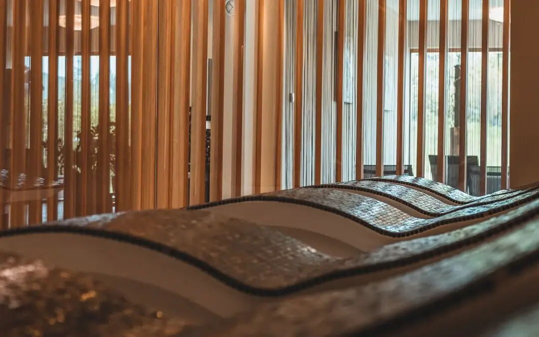 Stone heated loungers in an interior with wooden slats.