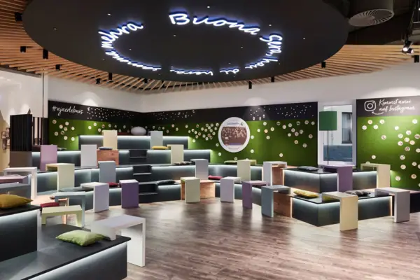 A room with lots of colourful benches and tables.