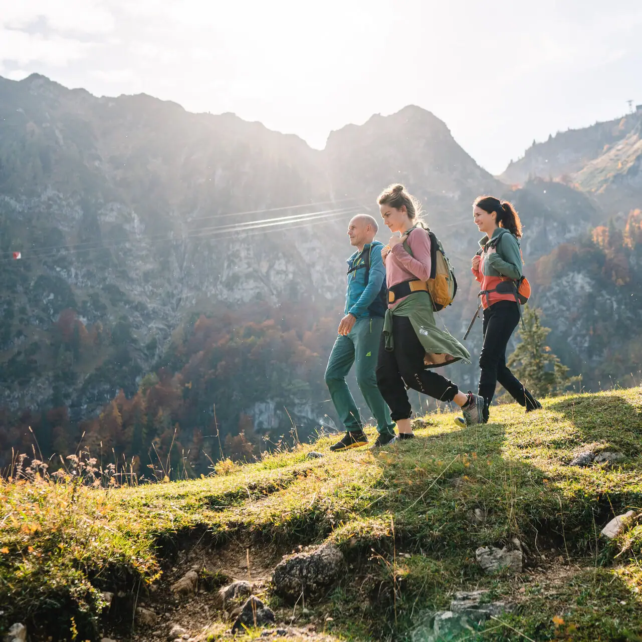 Hiking in Ruhpolding A group of people walking on a hill with mountains in the background.