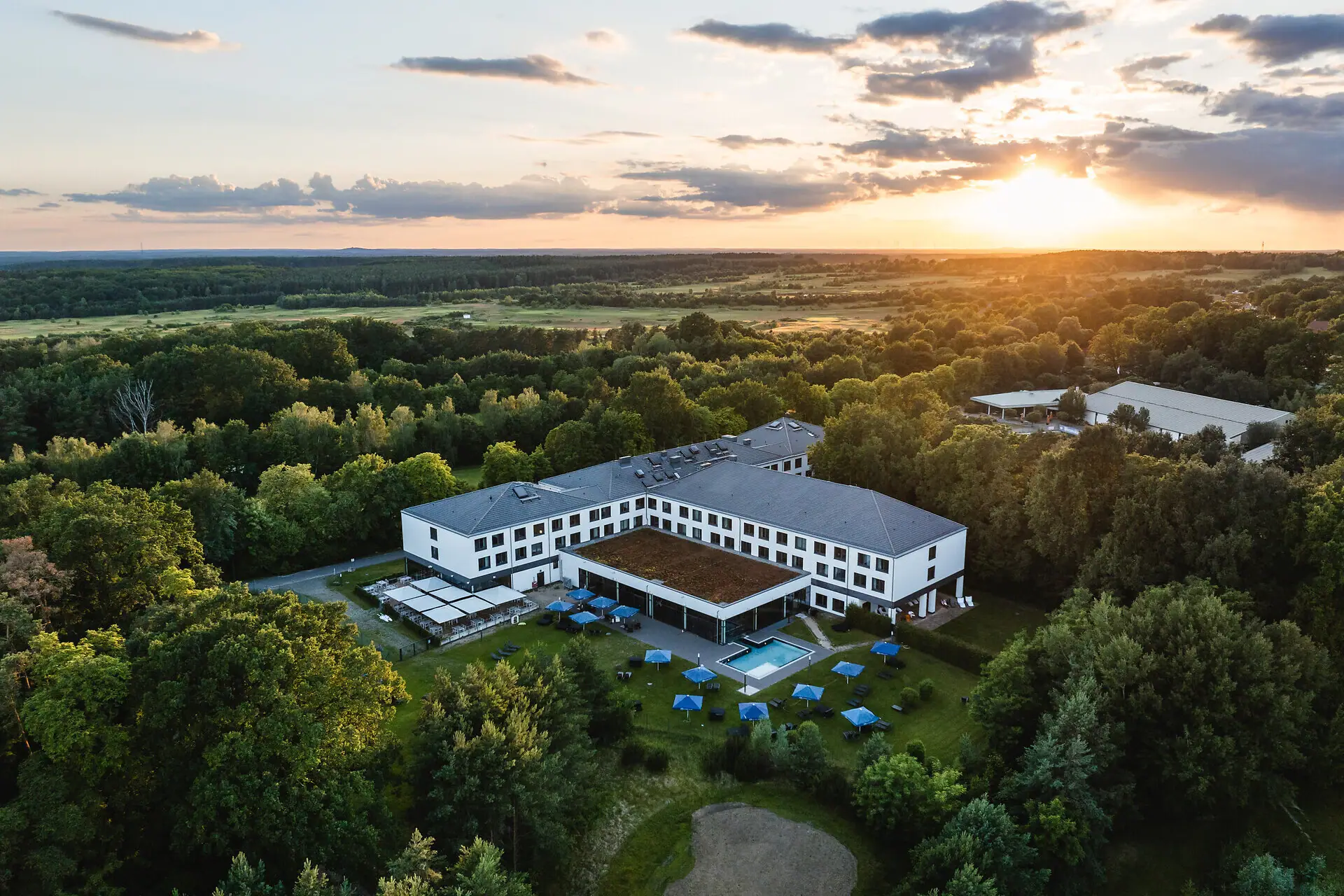 A building with a pool surrounded by trees.