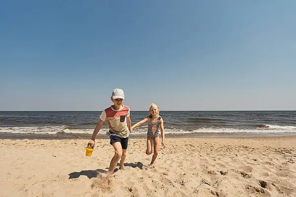 Strandtag Ein Junge und ein Mädchen rennen am Strand.
