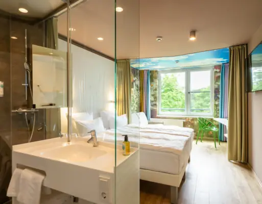 aja Bad Saarow Rooms A room with a glass shower and two beds.